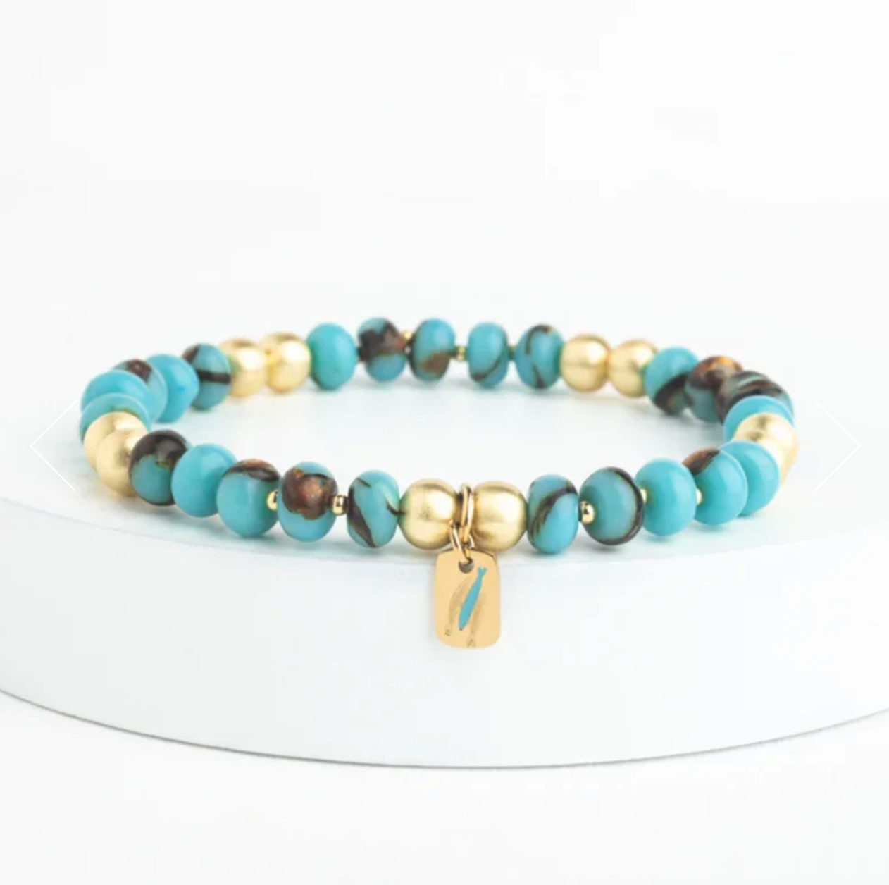 Multicolored beaded bracelet with a gold tag on a white background